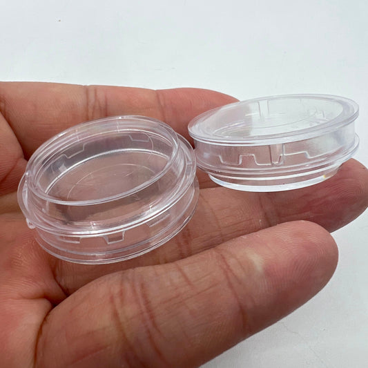 1. Stack of clear plastic watch movement storage boxes in assorted sizes.