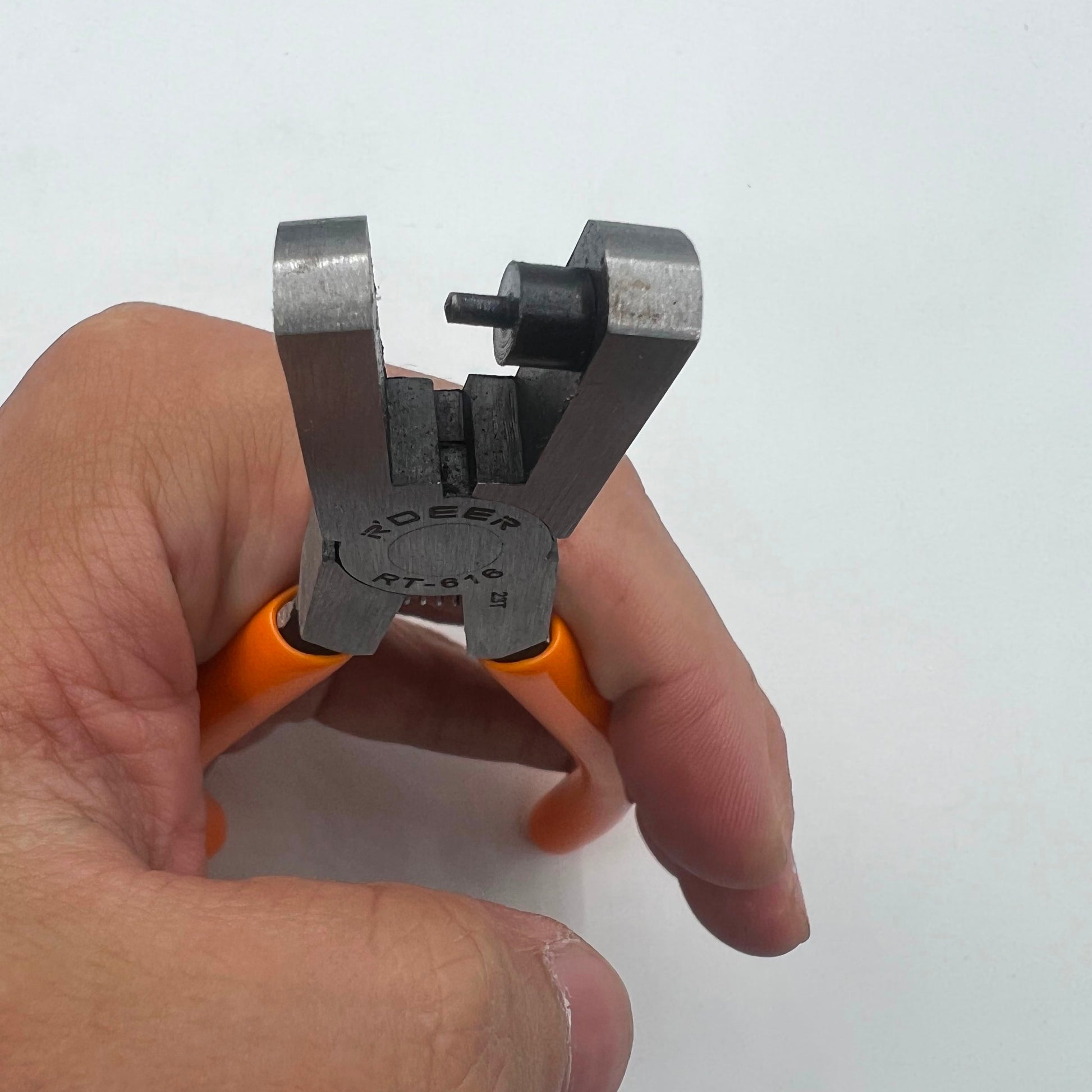 RT616 punch pliers creating precise 2mm holes in watch belt tag tape for repair.