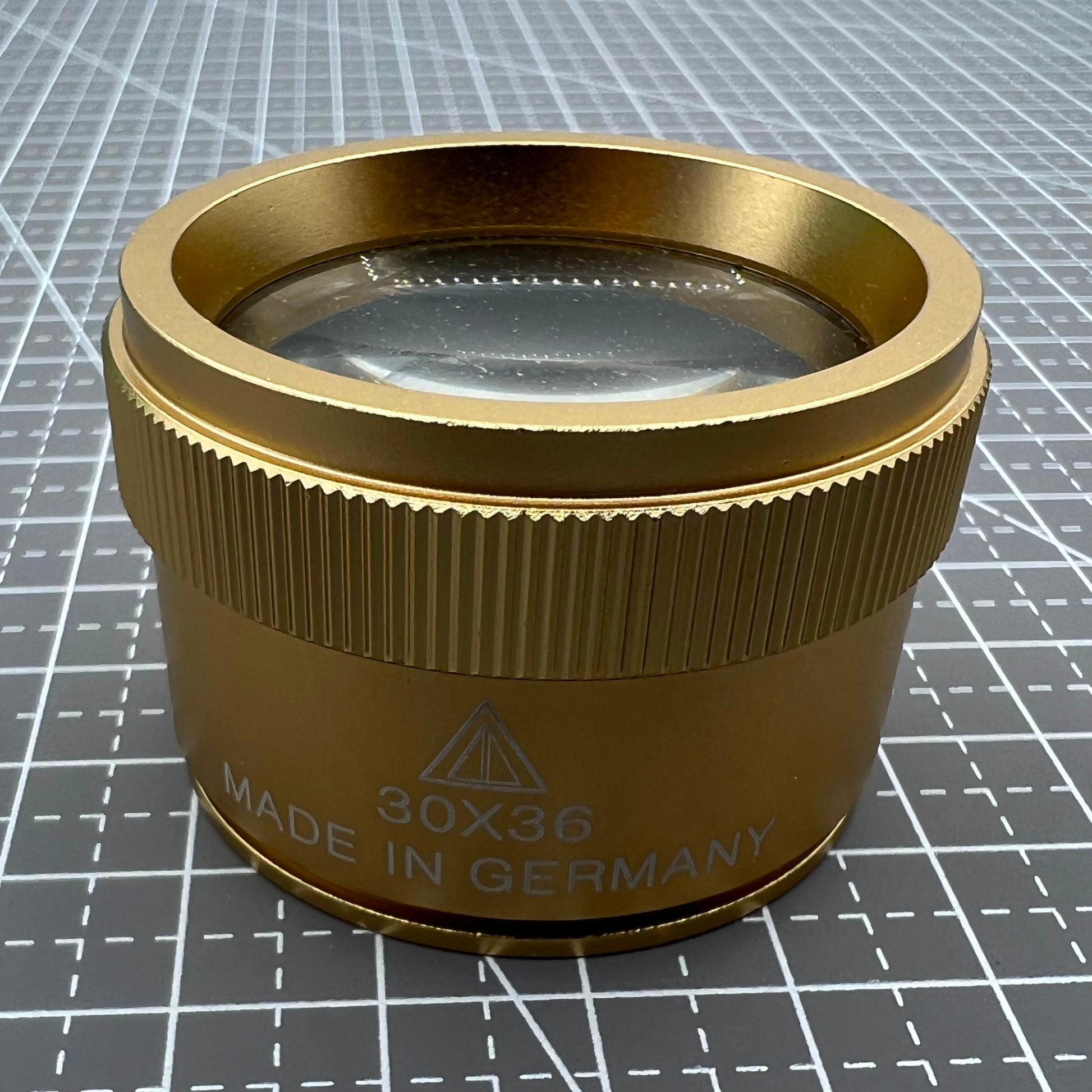 Bright golden 30X magnifier loupe by Germany Made for detailed watch repair and jewelry inspection.