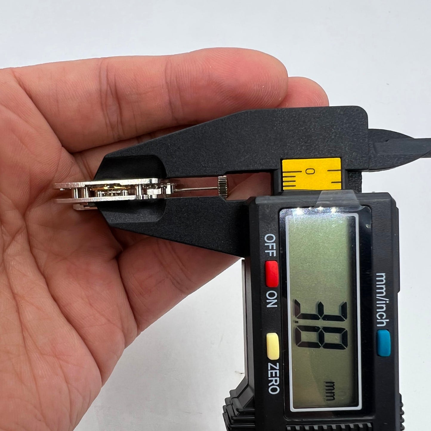 Silver barrel-shaped watch accessory with automatic mechanical movement, Asian craftsmanship.
