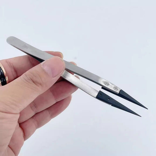 Stainless steel tweezers with carbon fiber tips for precision watch repair.