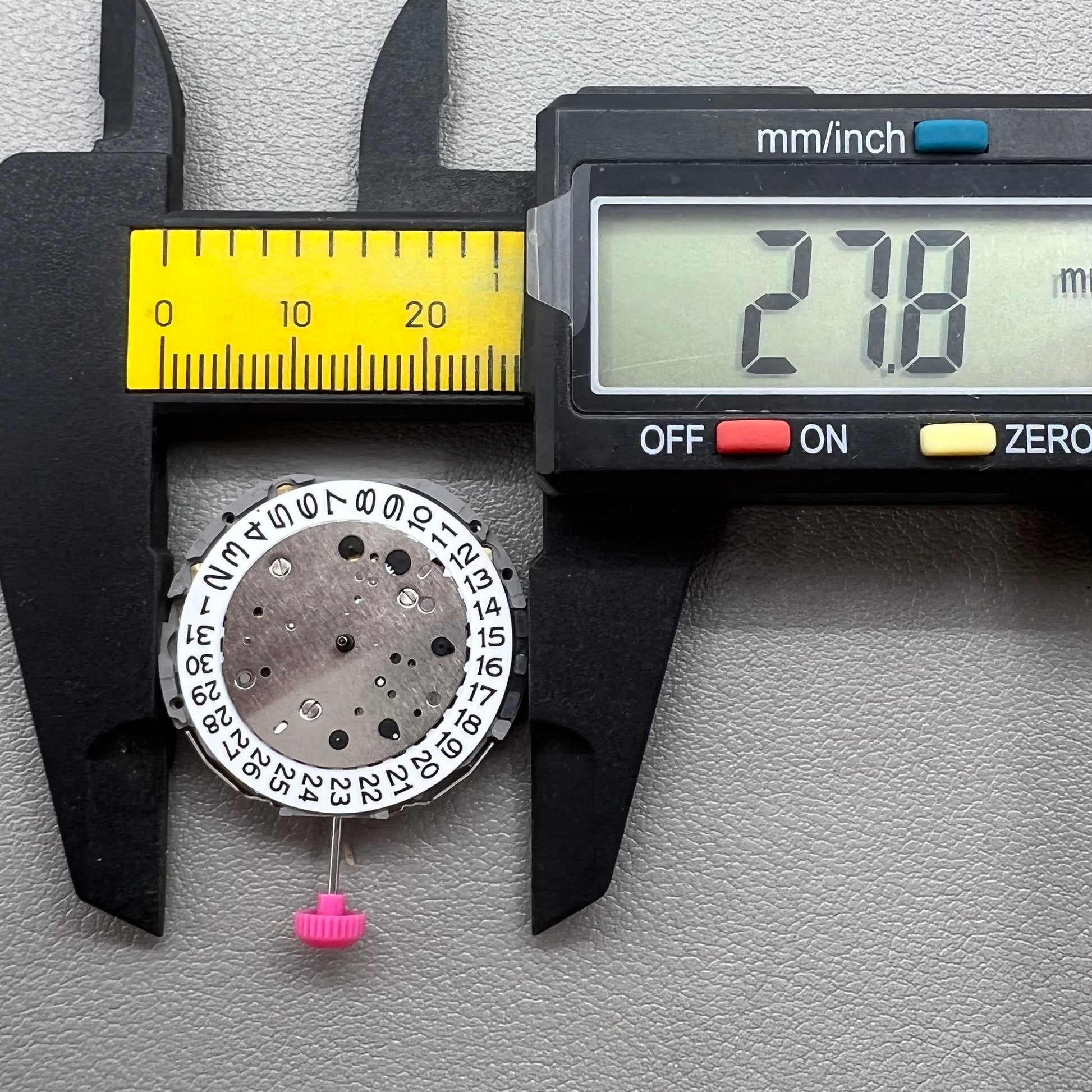 Japan Miyota JS25 watch movement close-up showing small second subdials at 3, 6, and 9 o'clock positions.