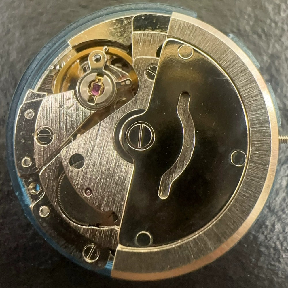 Tianjin Seagull 2813 watch movement with golden calendar disk for precise mechanical timekeeping.