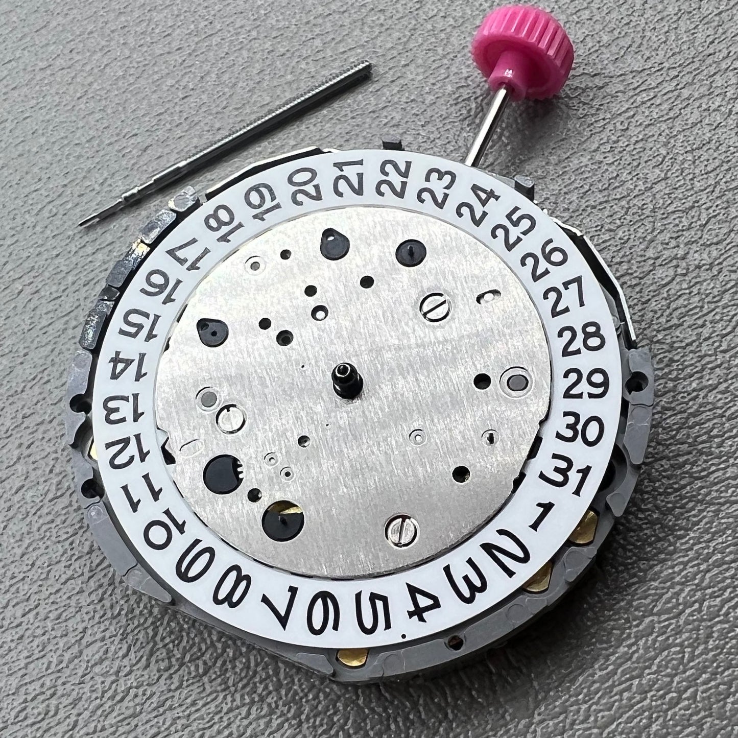 Japan Miyota JS25 watch movement close-up showing small second subdials at 3, 6, and 9 o'clock positions.