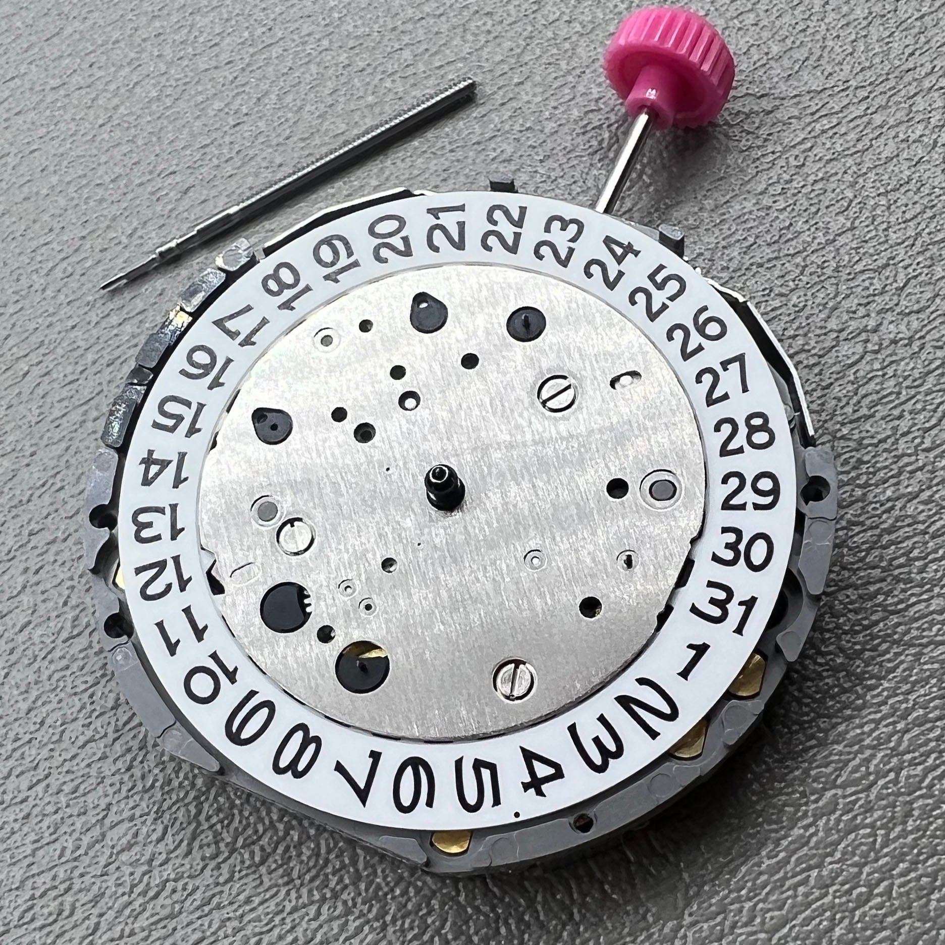 Japan Miyota JS25 watch movement close-up showing small second subdials at 3, 6, and 9 o'clock positions.