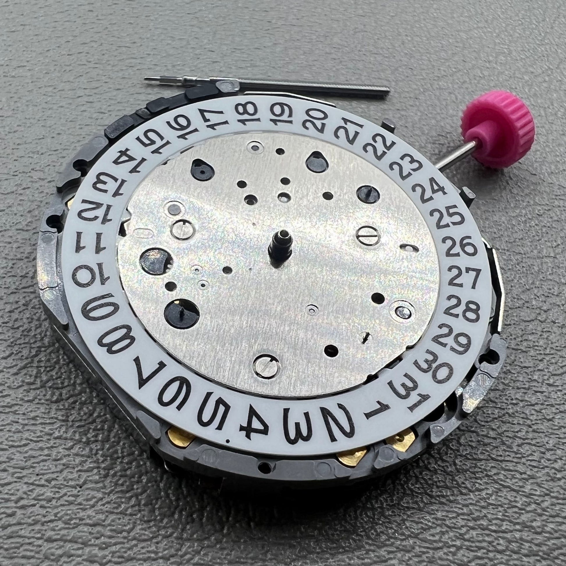 Japan Miyota JS25 watch movement close-up showing small second subdials at 3, 6, and 9 o'clock positions.