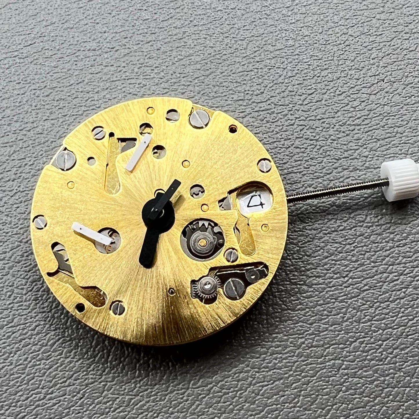 Swiss ISA 9232 quartz watch movement with six hands, date at 3, small seconds at 6/9/12, precision timekeeping.