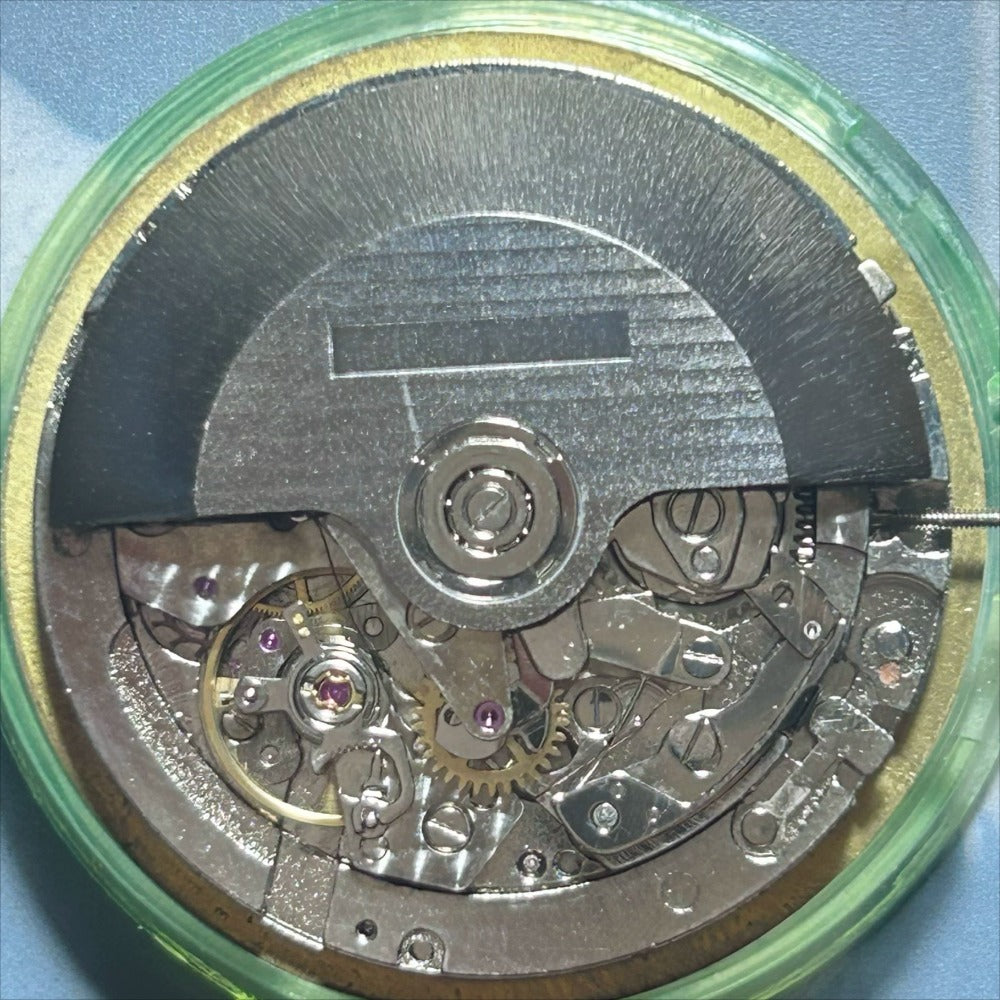 Dandong 7750 mechanical watch movement showing small seconds at 6, 9, and 12 on black dial by Dandong.