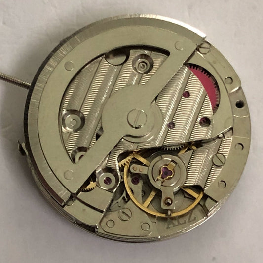 Close-up of China Made 2813 mechanical watch movement with single calendar and small second at 3, 6, and 9 o?clock positions.