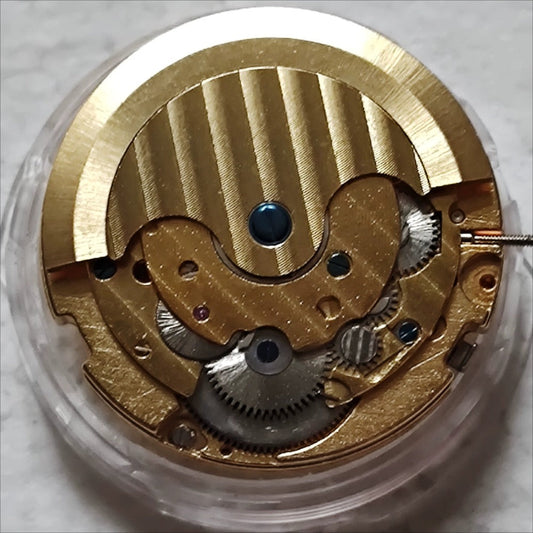 Golden LB automatic mechanical watch with moonphase at 12, bare wheel design, luxury timepiece detailed craftsmanship.