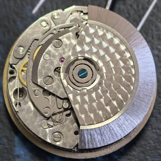 Close-up of Chinese Dandong 7750 mechanical watch movement featuring small second subdials at 3, 6, and 9 o'clock positions.
