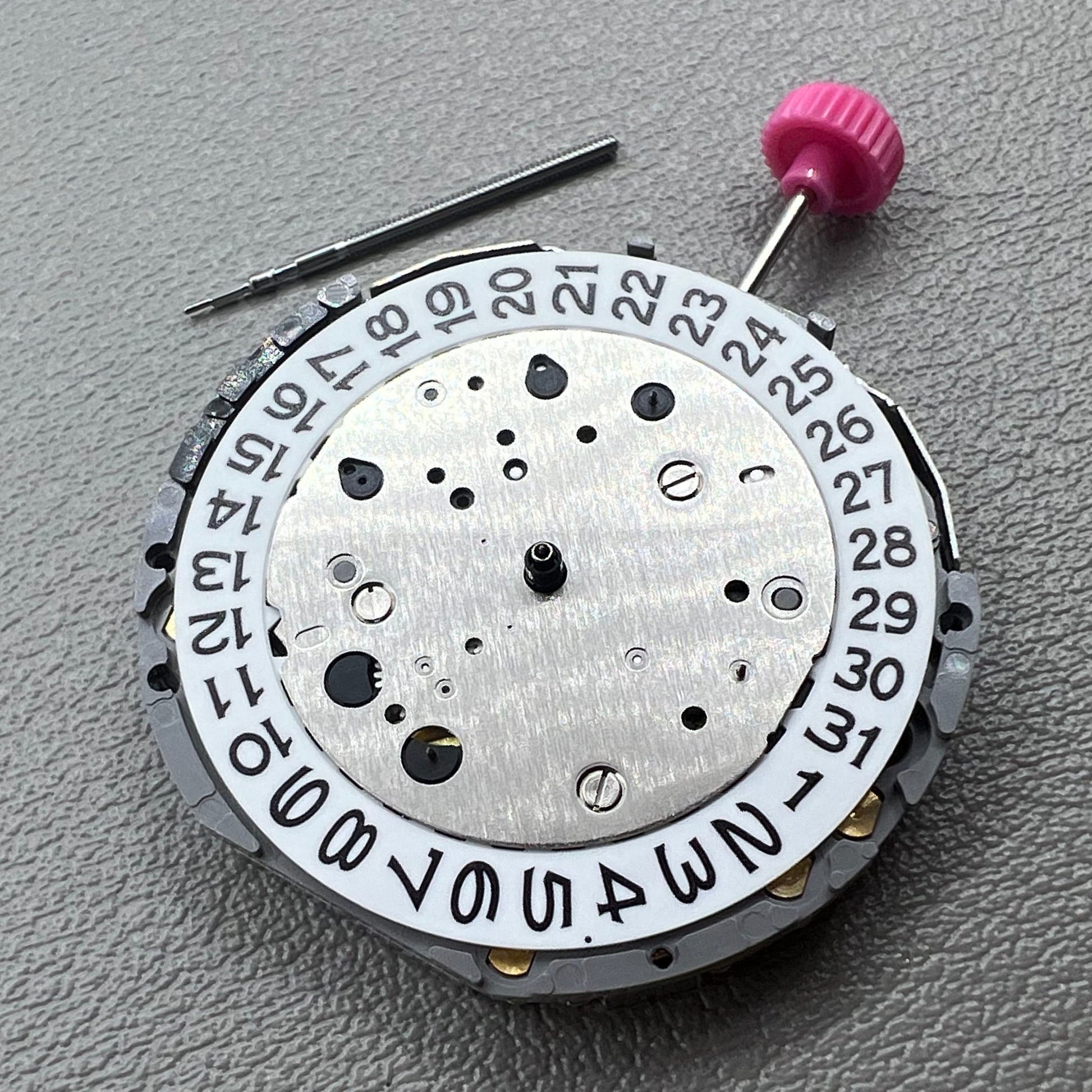 Japan Miyota JS25 watch movement close-up showing small second subdials at 3, 6, and 9 o'clock positions.