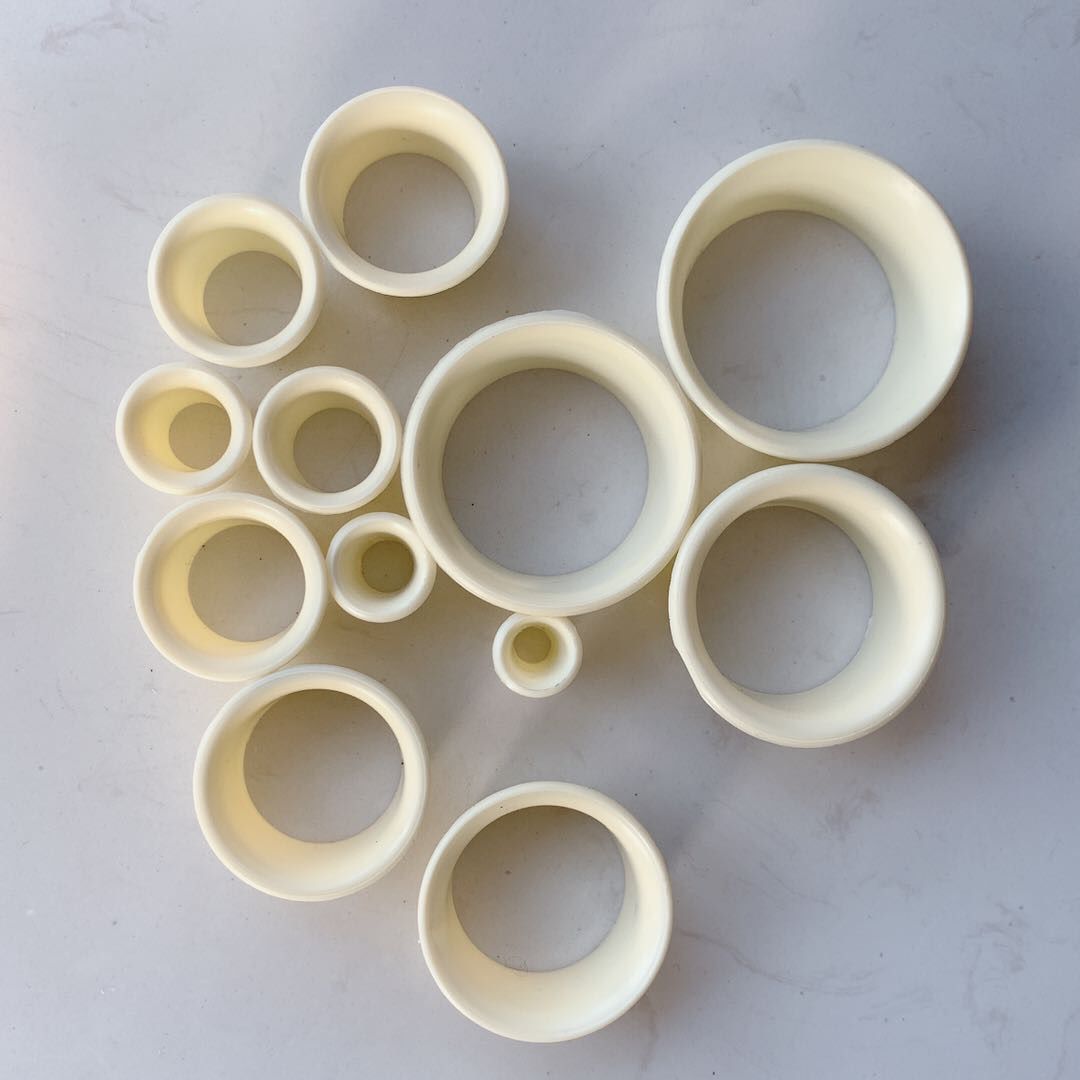 Set of 12 Duracell plastic watch movement holders stacked for secure watch repair parts storage.