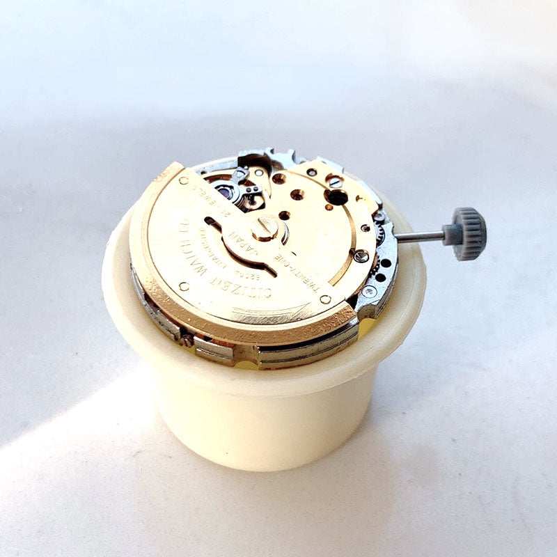 Set of 12 plastic watch movement holder boxes, stacked for secure watch repair parts storage.