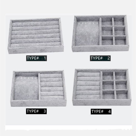 Stackable gray velvet jewelry organizer tray, ideal for displaying rings and necklaces.