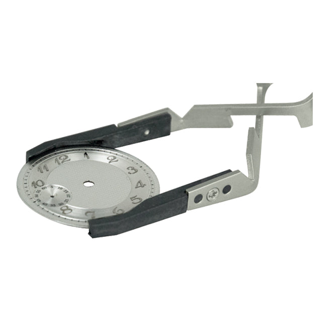 Bergeon 7140 cross locking tweezers holding watch crystals and dials for precise accessory handling.