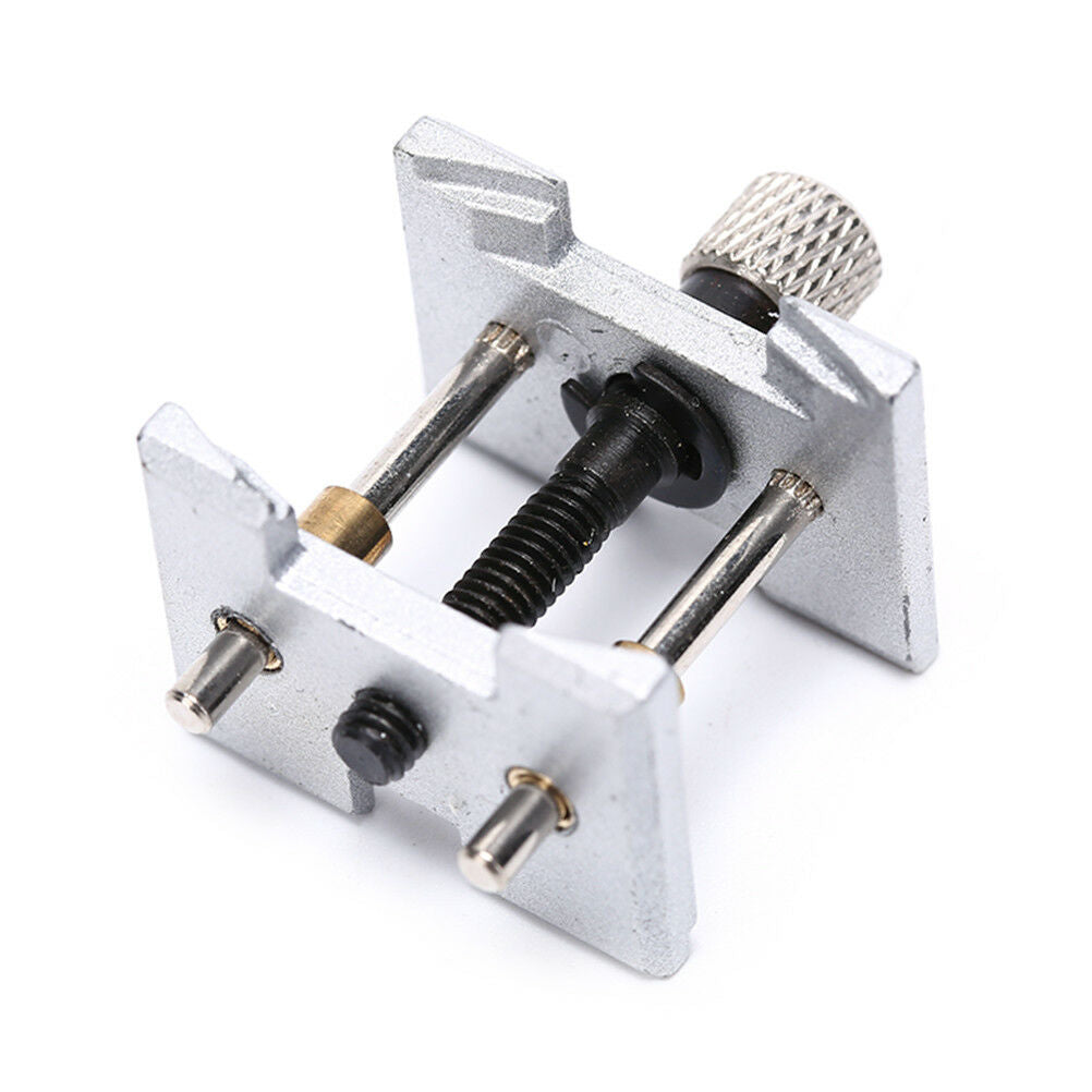 Precision metal watch movement holder clamp for secure watch repair and adjustment tasks.