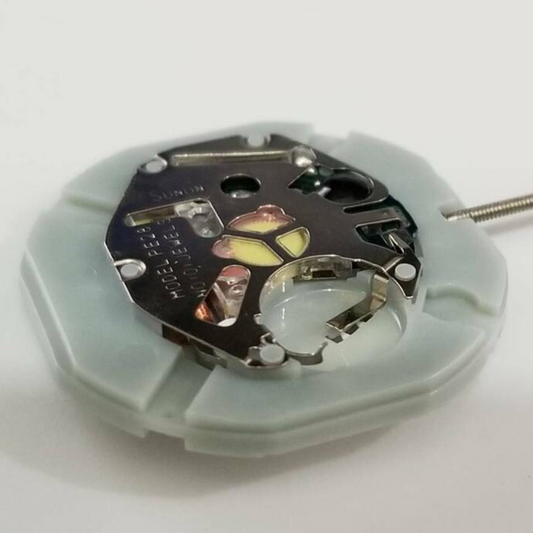 Close-up of SUNON PE28 quartz movement watch repair part for precise timekeeping.