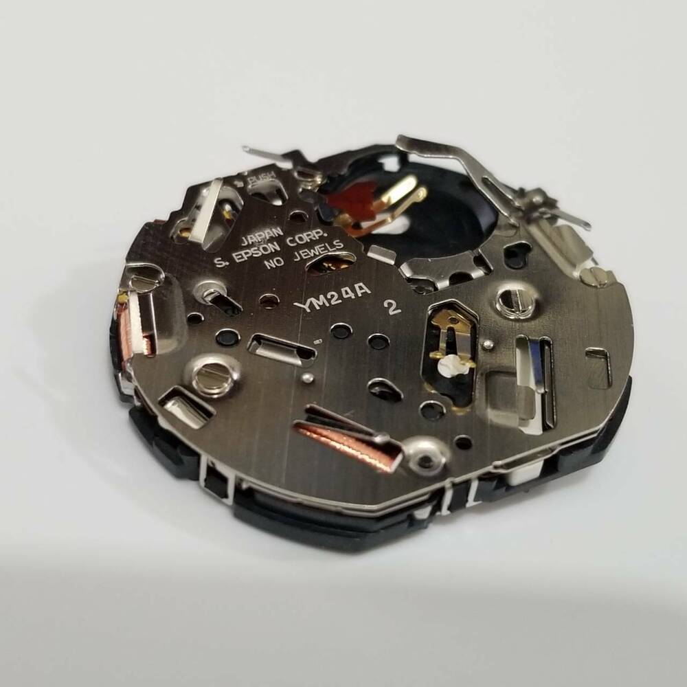 S. Epson YM24 quartz watch movement showing precision gears for accurate timekeeping and repair.