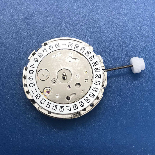 DG2813 watch movement close-up showing automatic mechanical gears, date display at 3 o'clock, silver finish