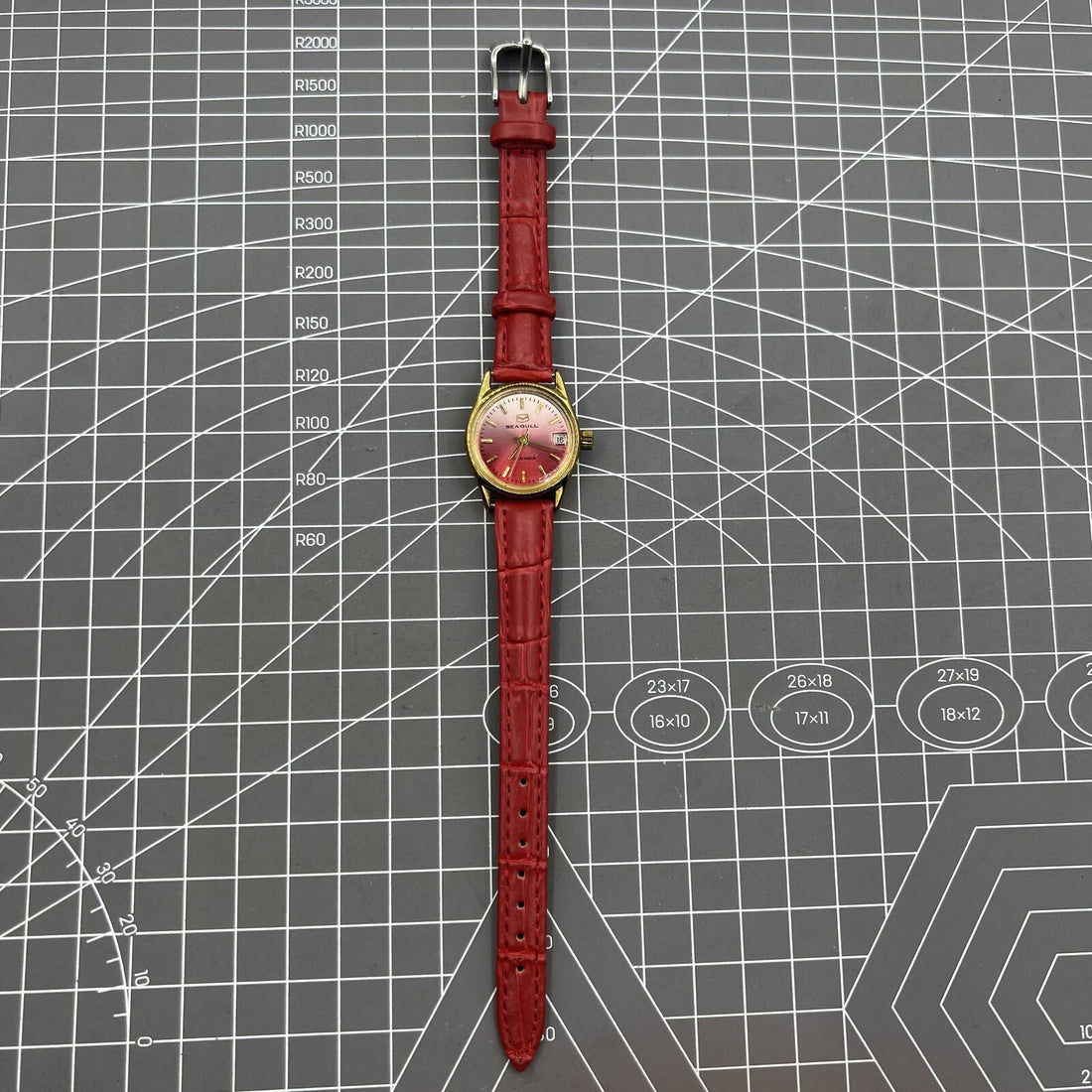 Seagull red dial Manual Mechanical Lady watch with gradient golden nails and single calendar display.