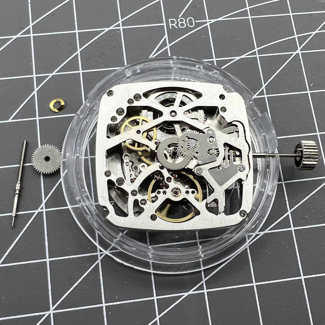 Tianjin Seagull ST25 square watch with silver 3-hand dial and visible automatic mechanical movement.