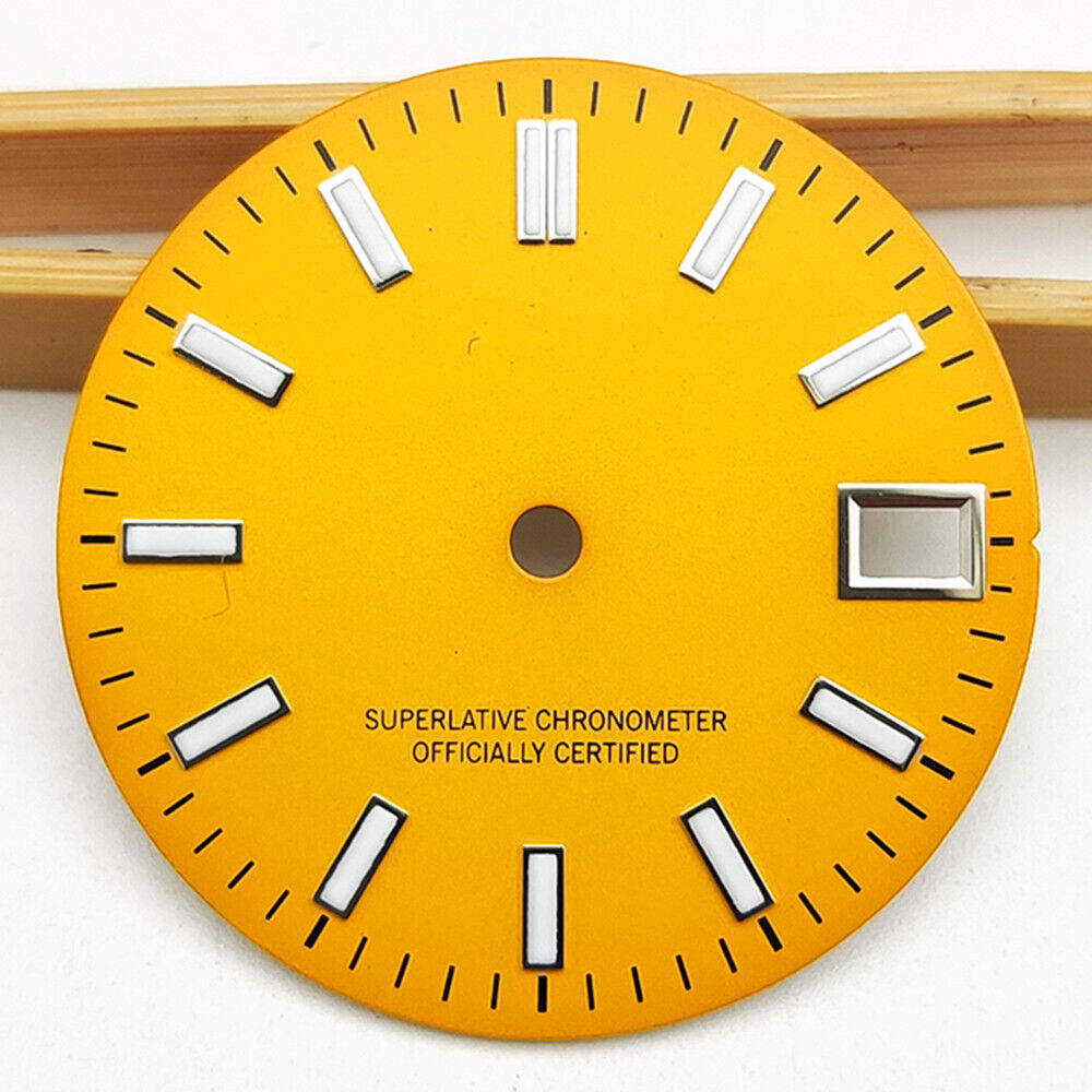 Polished orange metal watch dial with green luminous markers for NH35 movement.