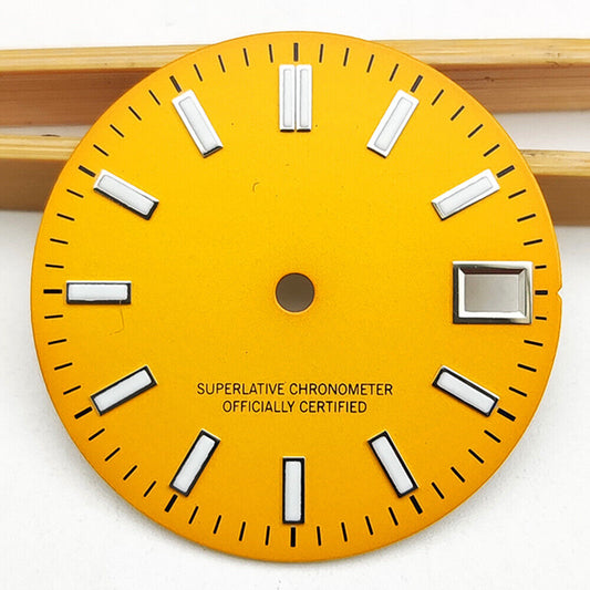 Polished orange metal watch dial with green luminous markers for NH35 movement.