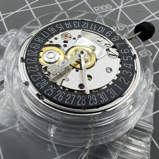 Seagull 2824 automatic watch movement showing date at 6 o'clock with black disk wheel for precision timekeeping.