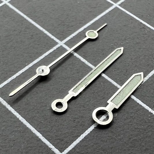 Silver-trimmed green luminous watch hands for Miyota 1M12 movement, perfect for precise time visibility.