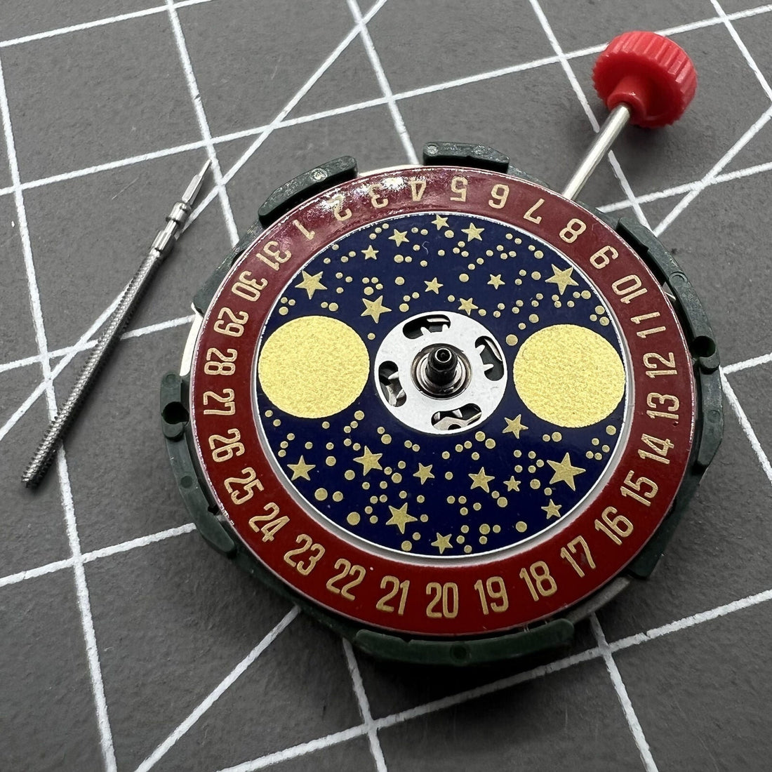 Miyota 2105 quartz watch movement with red dial and star moon phase display, precise timekeeping accessory.