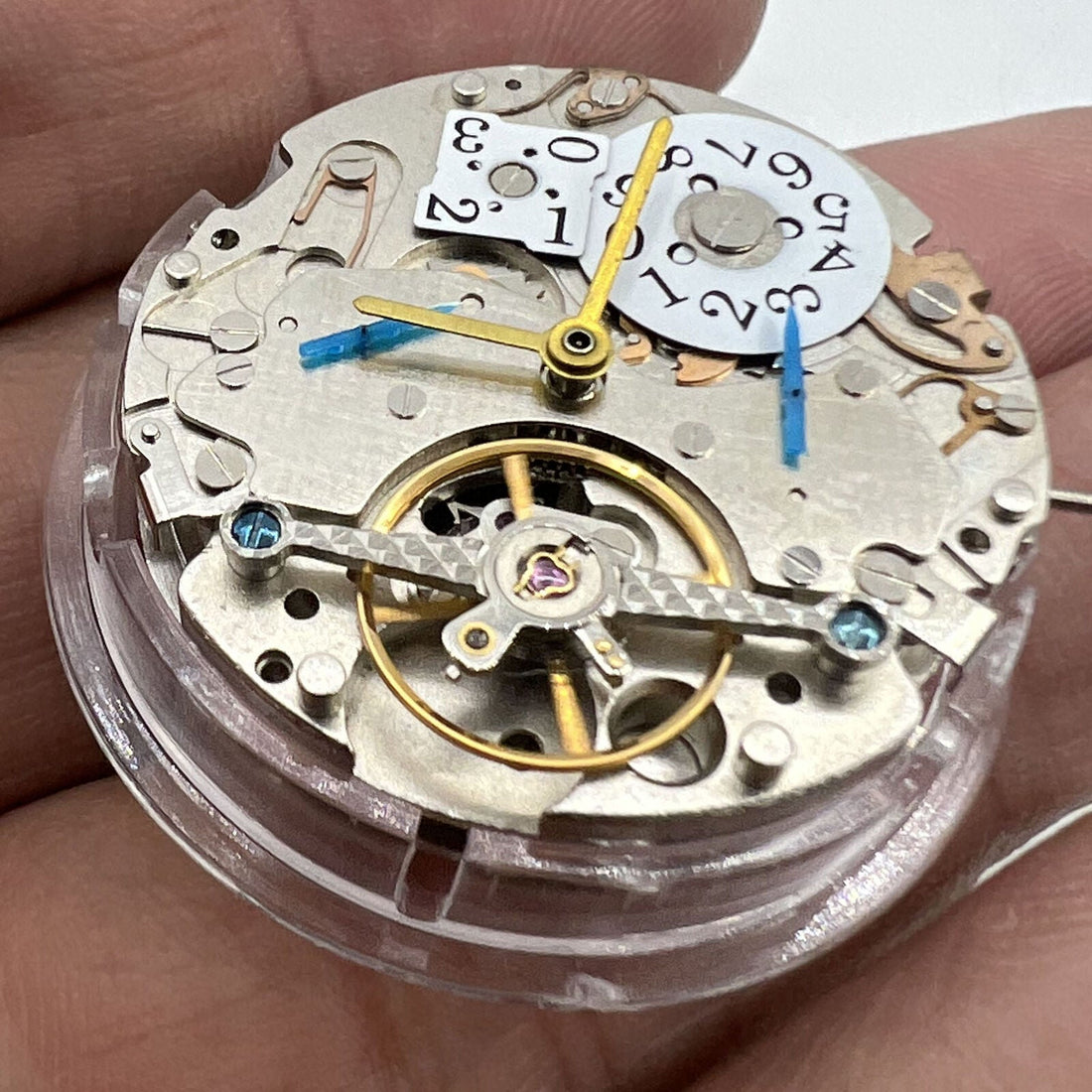 Asian automatic watch with multifunctional date at 12 o?clock and bare balance wheel visible.
