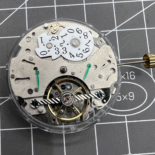 Automatic mechanical watch with reversed balance wheel, big date at 12, precision timekeeping.