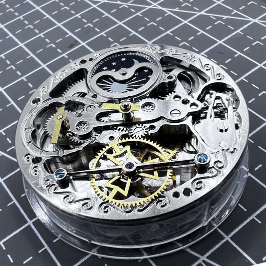 Silver hollow movement watch accessory with small bare balance wheel at 6 o'clock, featuring double mainspring by Double Mainspring.
