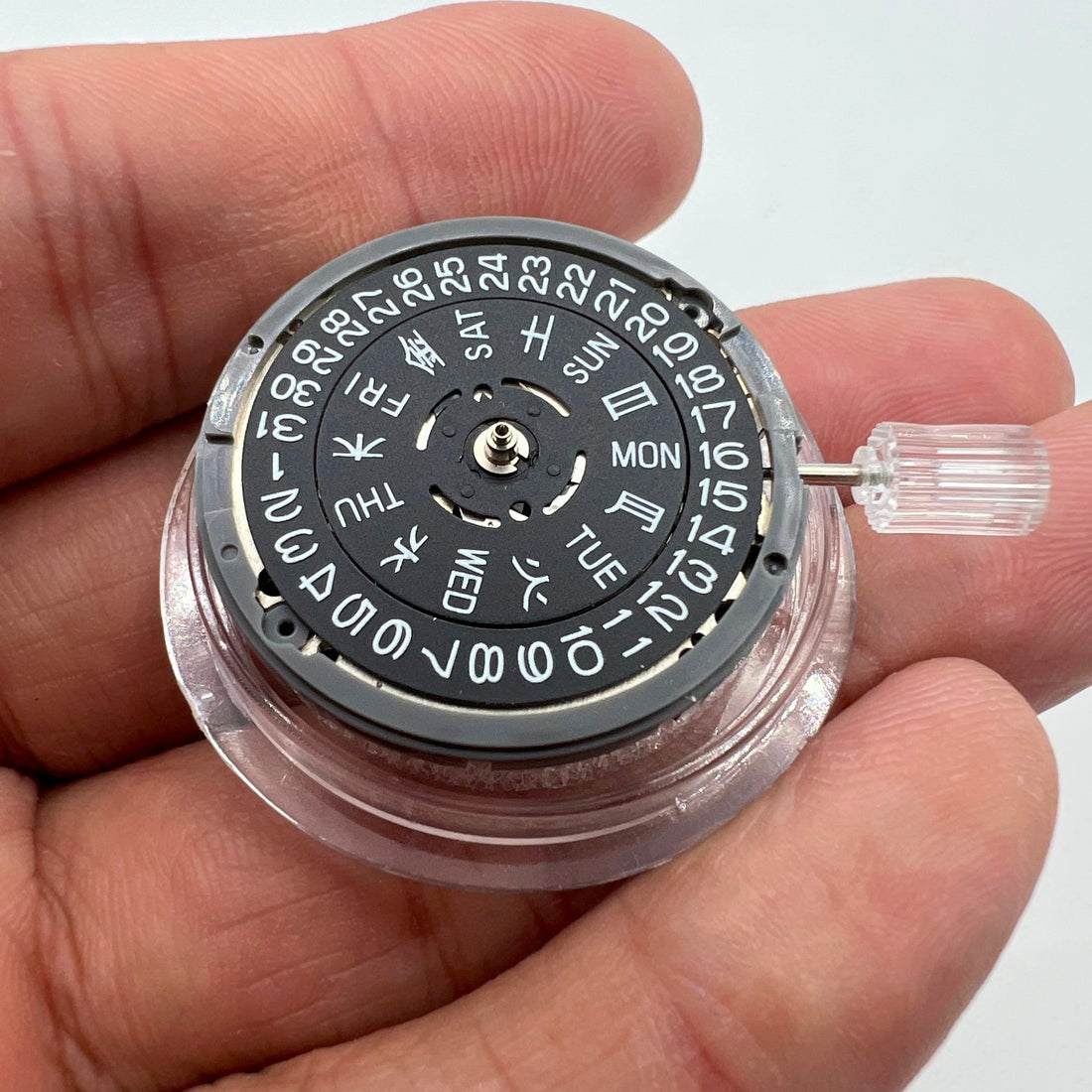 Miyota NH36A watch movement with black finish and green lume on dial, showcasing 3 crown positions for precise time setting.