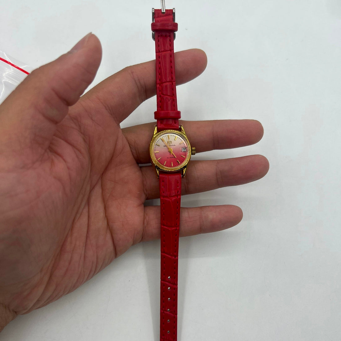 Seagull Lady watch with red gradient dial, gold nails, manual mechanical movement, single calendar display.