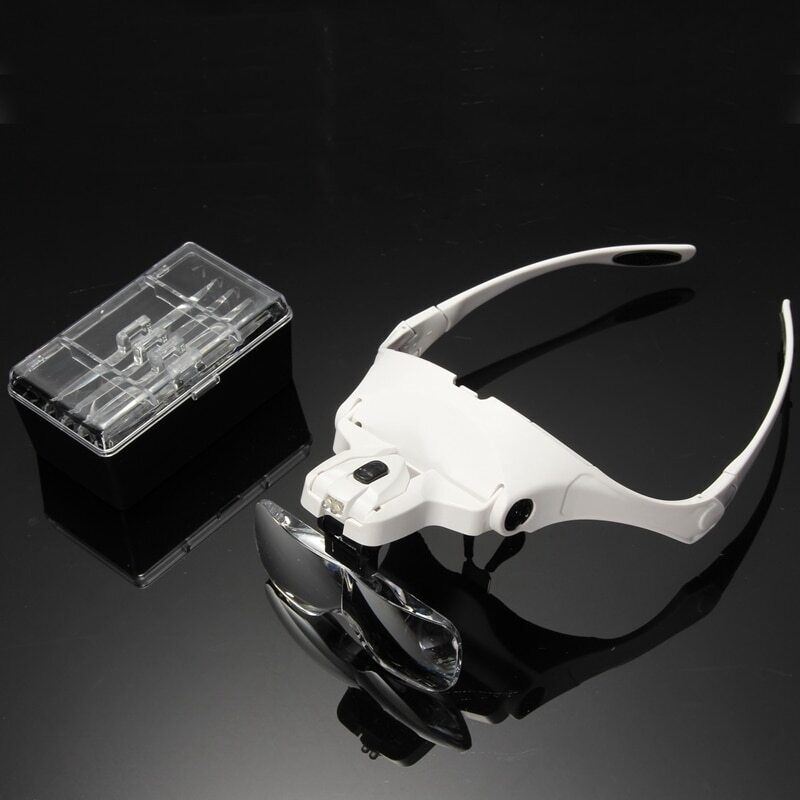 Adjustable reading watch loupe headband with LED light for detailed jewelry inspection.