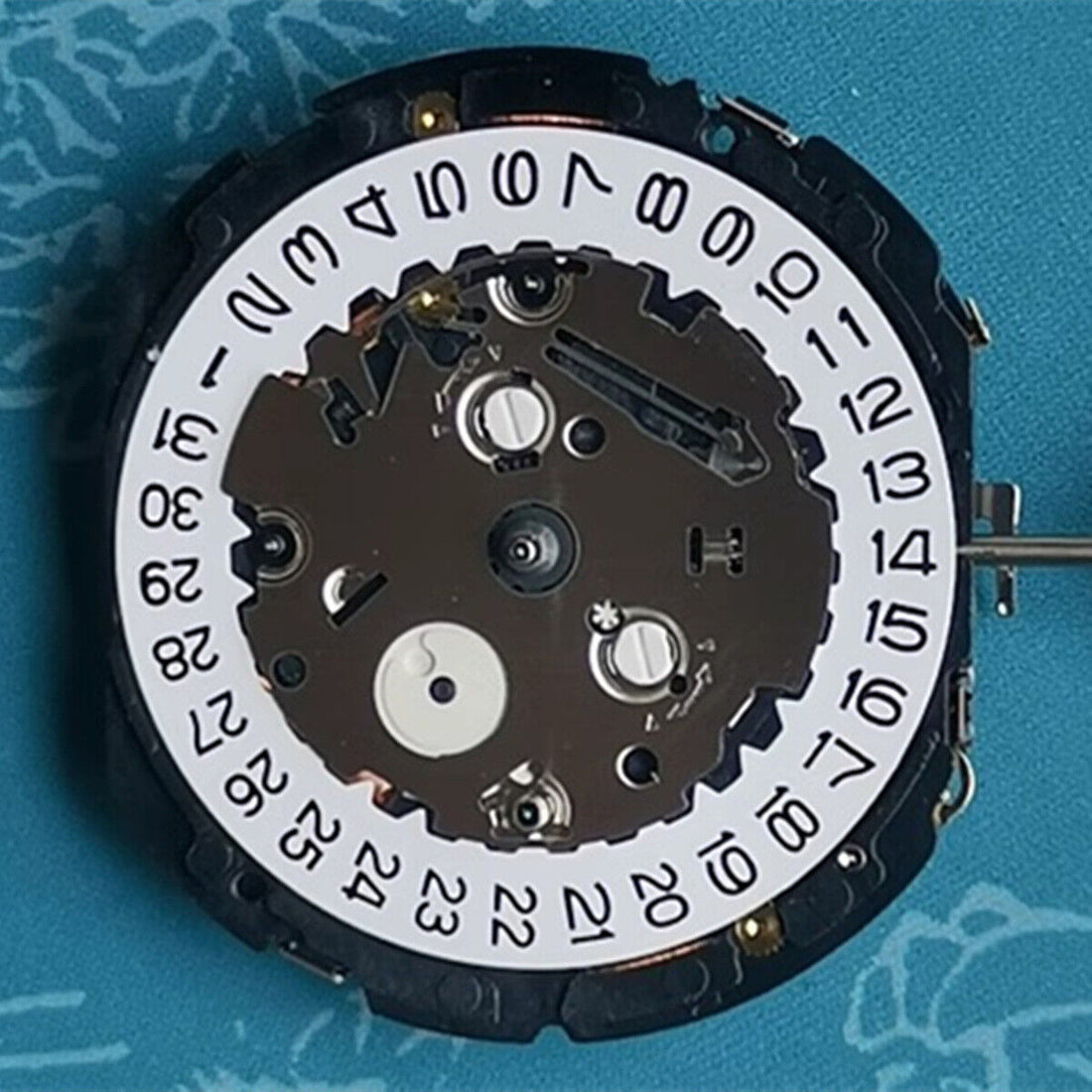 Orient KFB00 quartz watch movement with date at 3, white disk, Japan made for precise timekeeping.