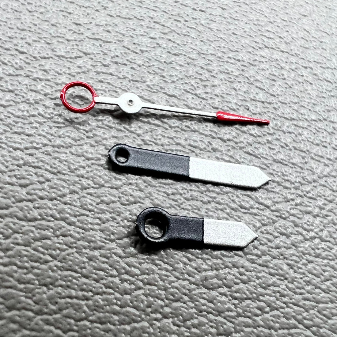 Set of black and white painted trim arrow-shaped watch hands without lume for Ronda 515, ideal for precise timekeeping.