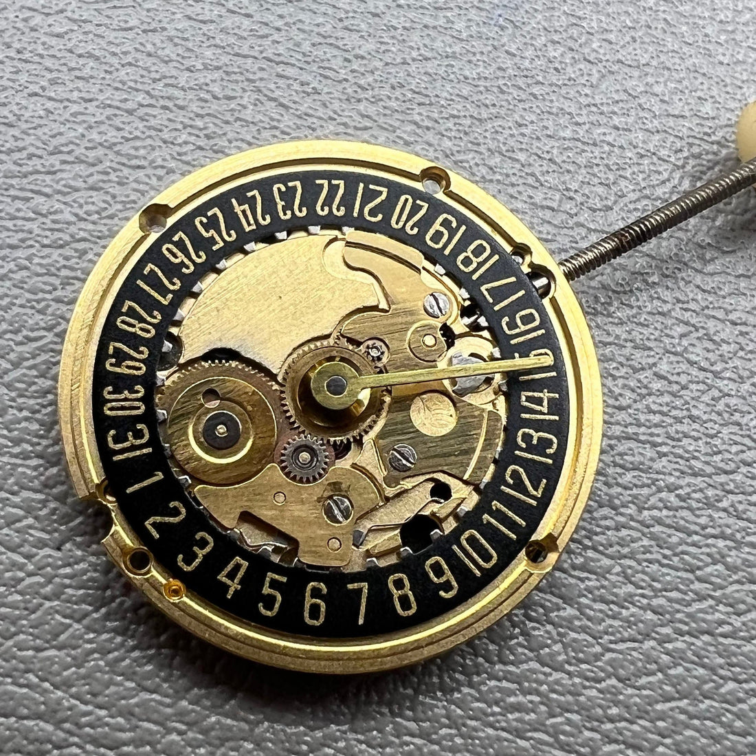 Swiss ETA 256.041 quartz watch movement with black disk, 2 hands, and date at 6, precise timekeeping.