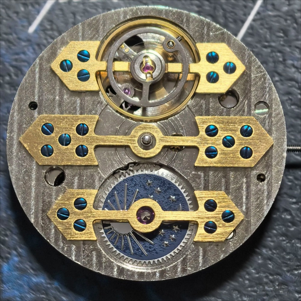 Silver and gold mechanical watch accessory with moon phase at 6 o'clock by China Made, elegant timepiece detail.