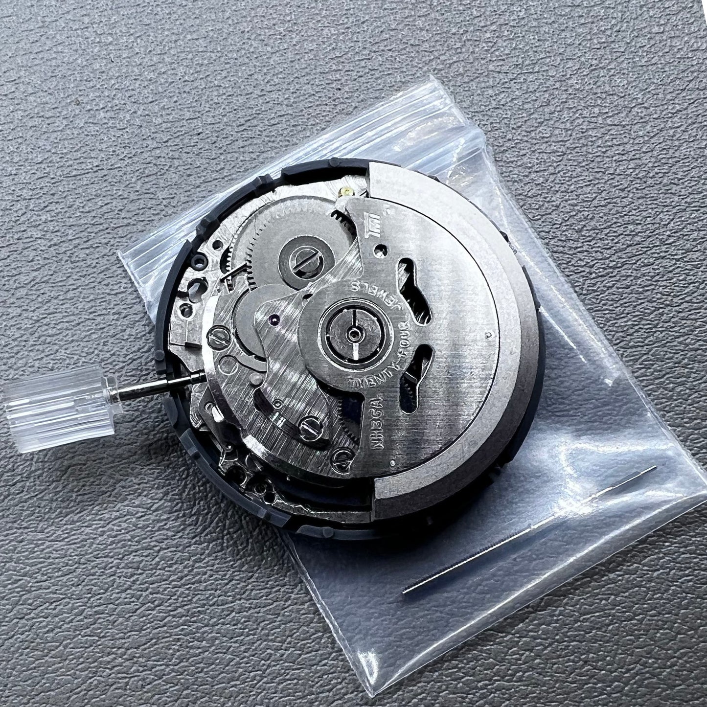 Seiko NH36 watch movement with black dial, Arabic numerals, date display, crown at 3:00 position
