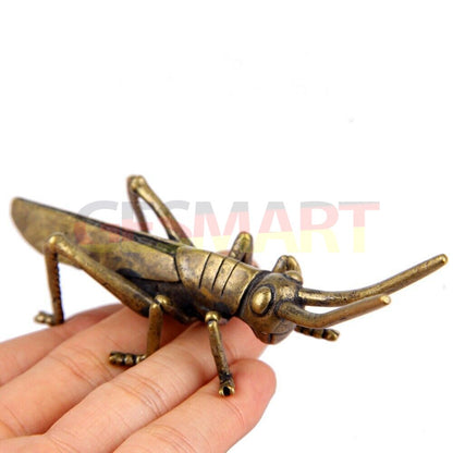 Hand-carved solid copper grasshopper figurine, vintage bronze finish watch accessory detail.