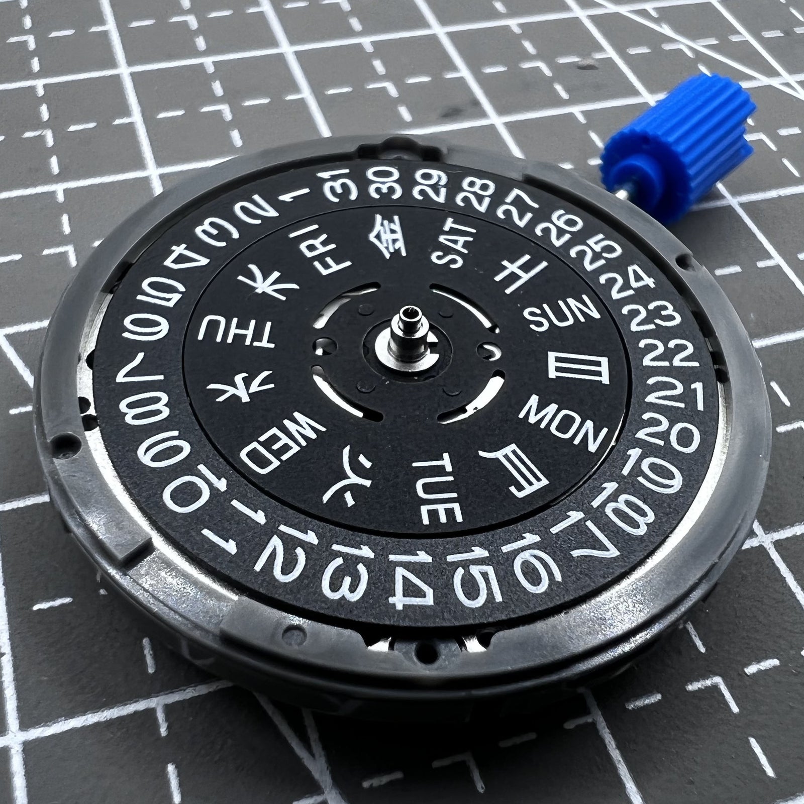 Seiko NH36A automatic watch movement with black finish and green luminescent markers, crown at 3:80 position.
