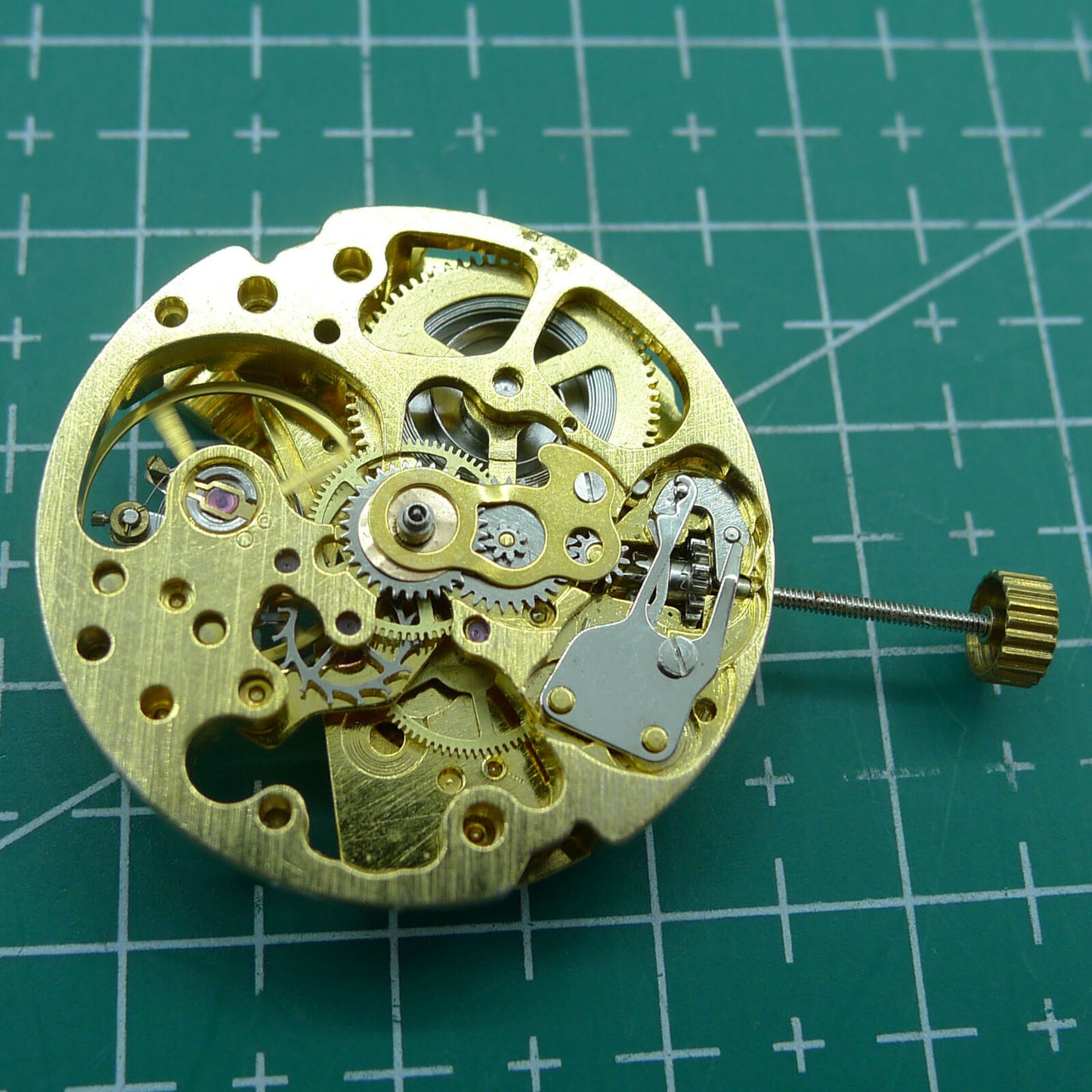 Golden 26.5mm DANDONG 7120 automatic mechanical watch movement with hollow design, precise craftsmanship.