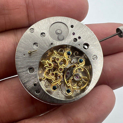 Multifunctional automatic watch featuring kinetic energy tourbillon and sleek mechanical design.