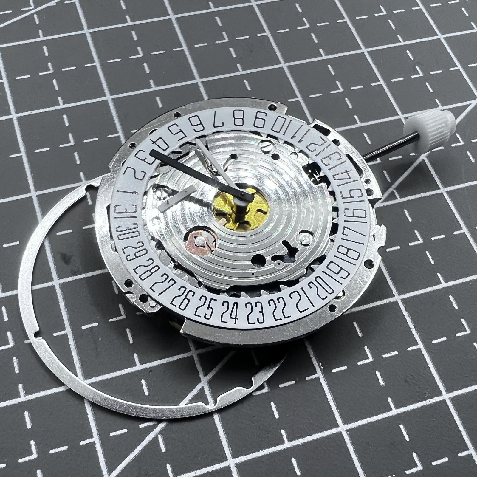 Swiss ISA 8171A quartz watch movement with white dial, four hands, and date at 6 o?clock for precise timekeeping.