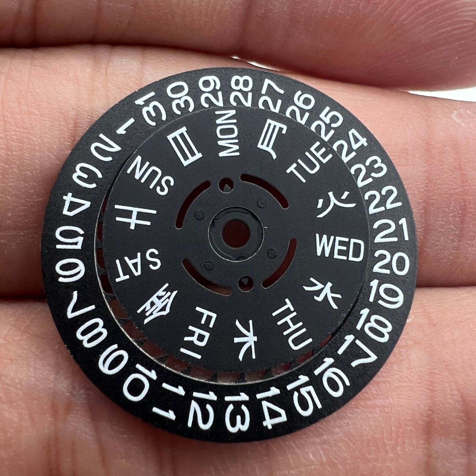 Blue and green lume date and week wheels for NH36 movement, black disk highlights date at 3.8 position.