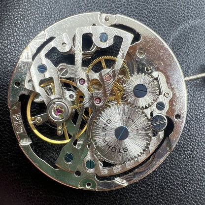 Hollow silver manual winding watch movement, highlighting intricate mechanical craftsmanship.