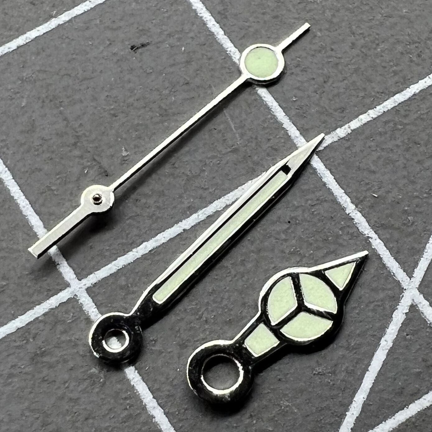 Silver-trimmed green lume watch hands set for Miyota 2035 movement, boosting readability and design.